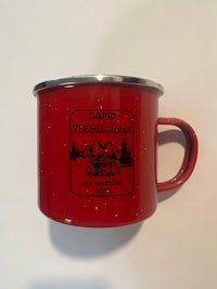 a red enamel mug with a logo on it