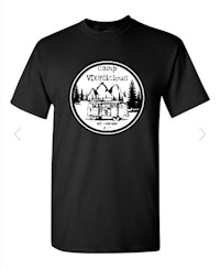 a black t - shirt with an image of a cabin in the woods